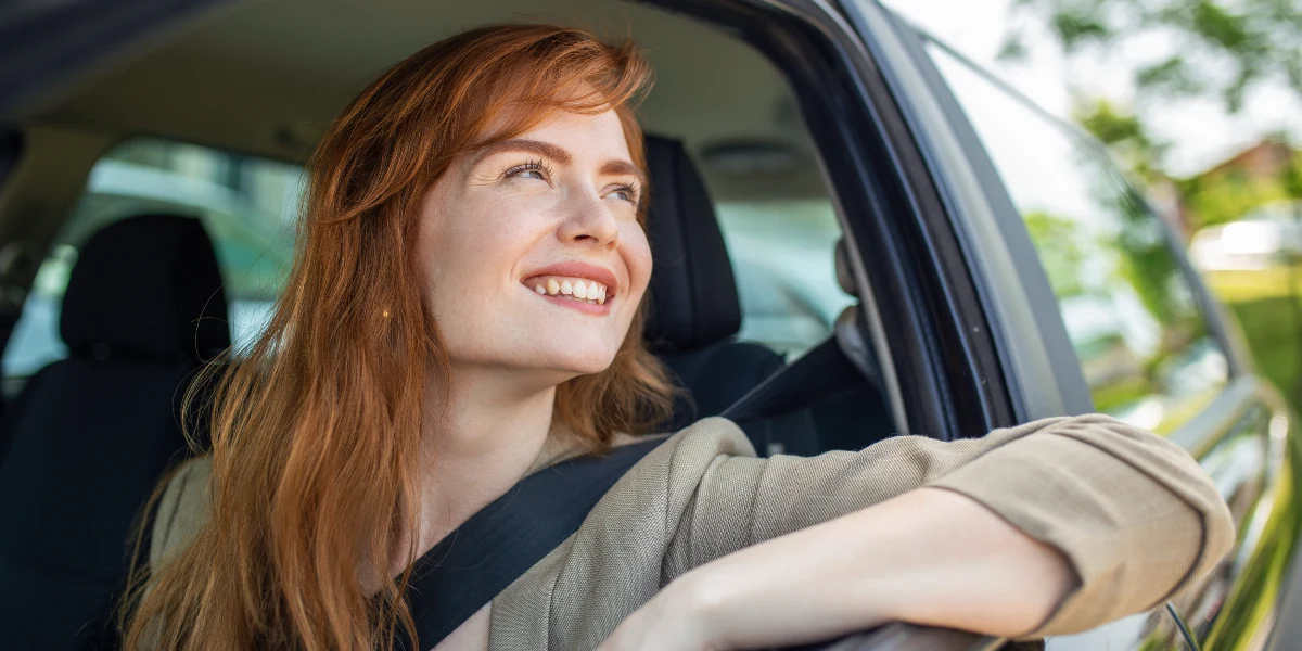 femme qui conduit une voiture de location