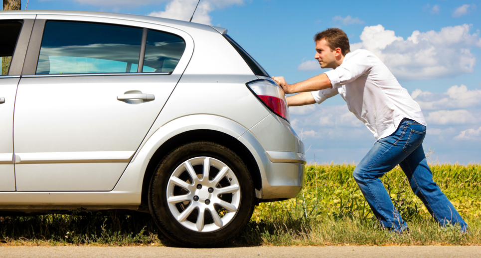 Homme qui pousse sa voiture